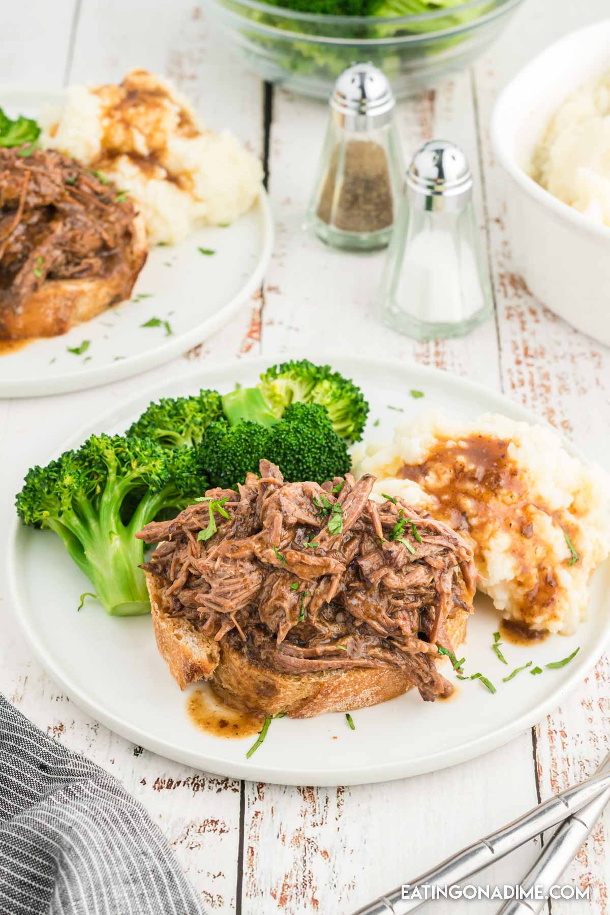 Shredded Roast Beef Sandwiches on a plate with a side of broccoli and mashed potatoes and gravy