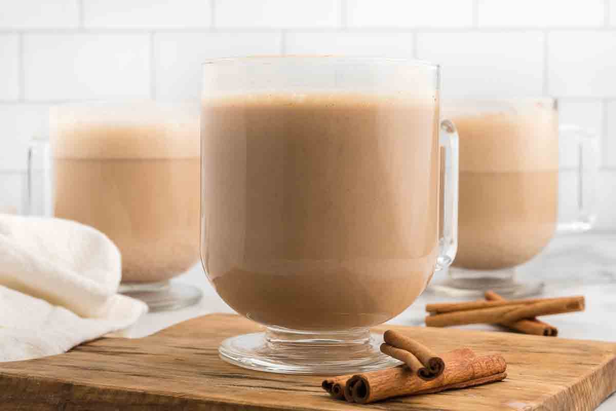 Starbucks Chai Tea Latte in a mug with cinnamon sticks on the side. 