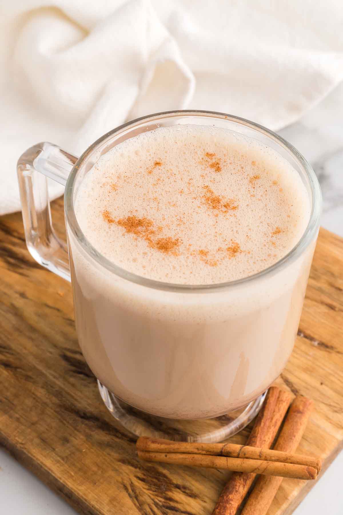 Starbucks Chai Tea Latte in a mug with cinnamon sticks on the side. 