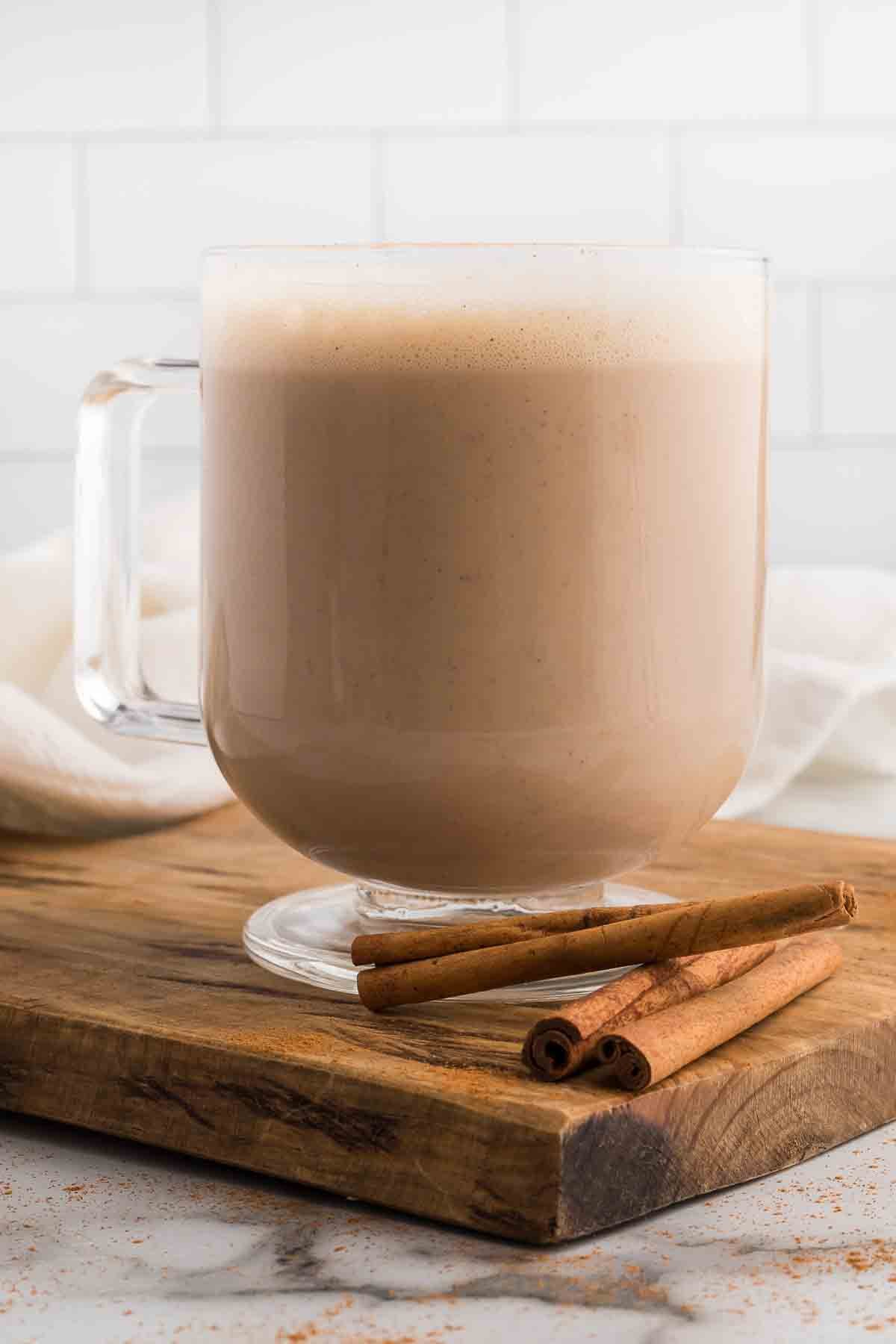 Starbucks Chai Tea Latte in a mug with cinnamon sticks on the side. 