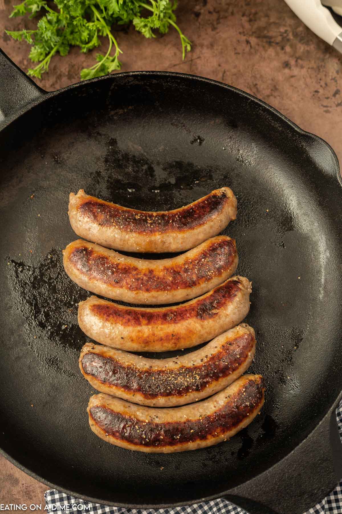 Close up image of Bratwurst in a cast iron skillet