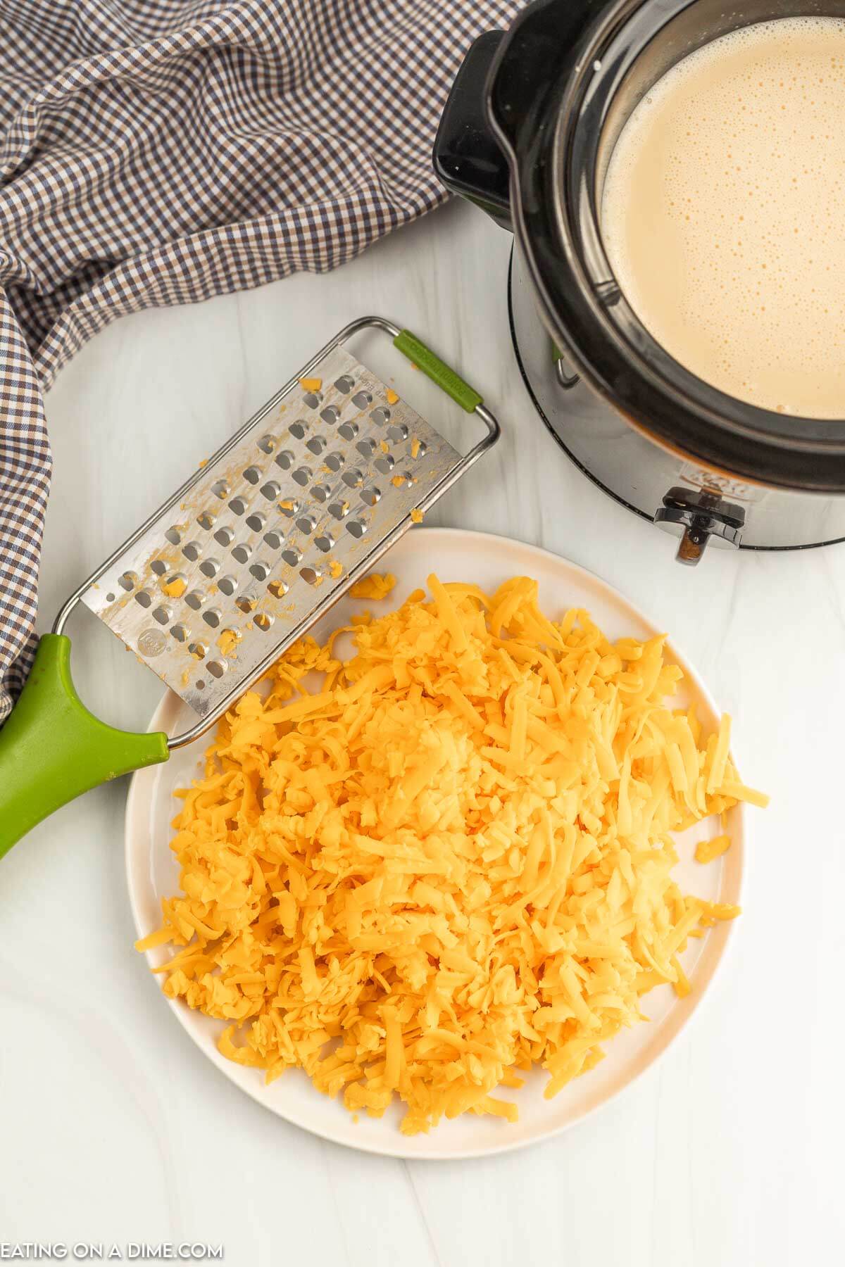 Shredded cheese on a plate with a cheese grater