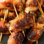A pile of bacon wrapped dates sits temptingly on the platter, each bite offering a perfect blend of salty and sweet flavors.