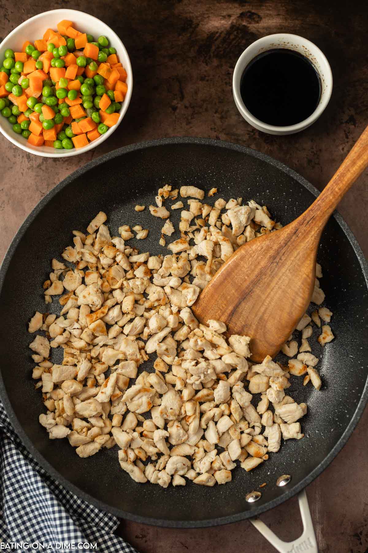 Cooking Chicken in a Skillet with wooden spoon