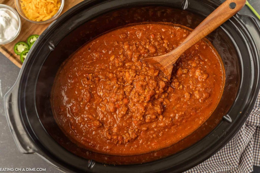 pumpkin chili in the slow cooker with a wooden spoon