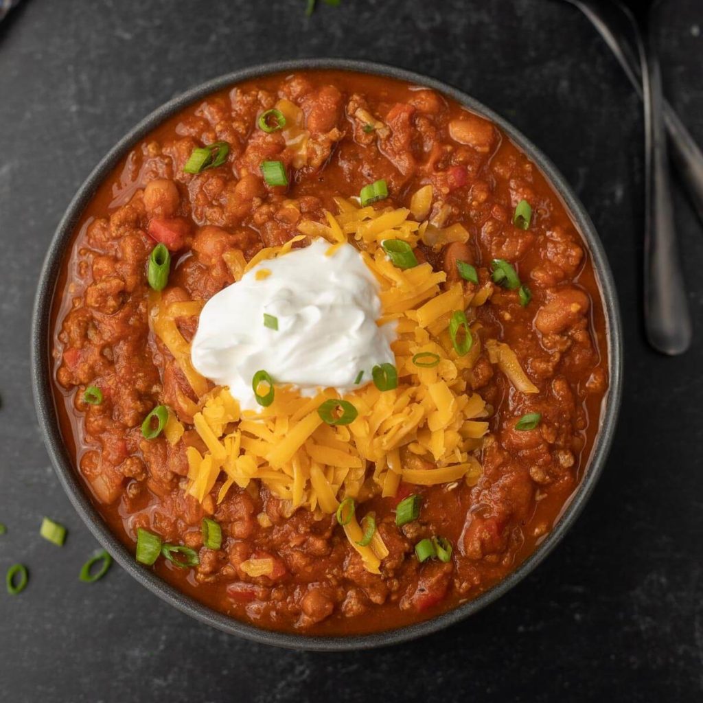a bowl of pumpkin chili topped with chili and sour cream
