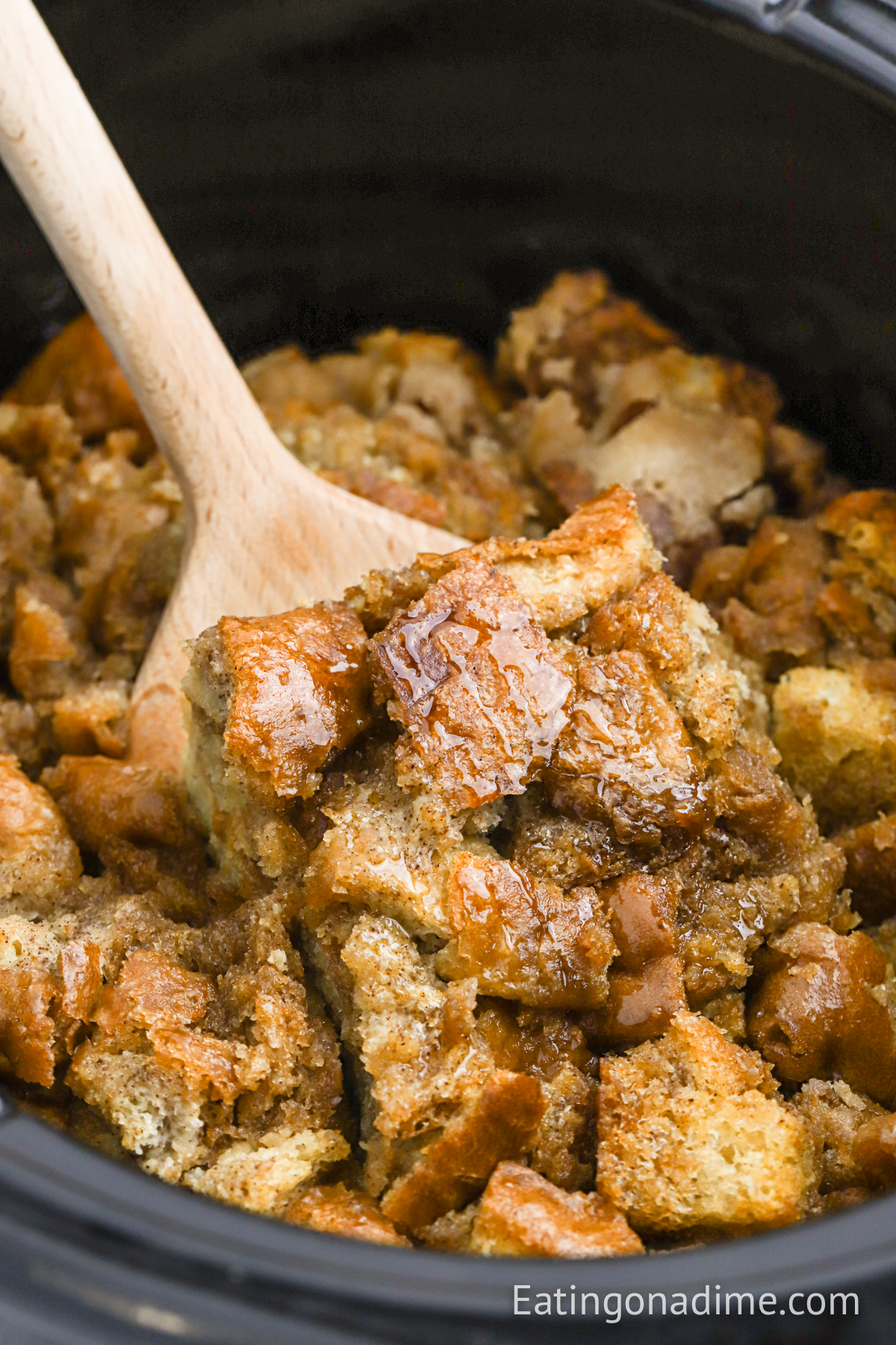 French Toast Casserole in a slow cooker with wooden spoon