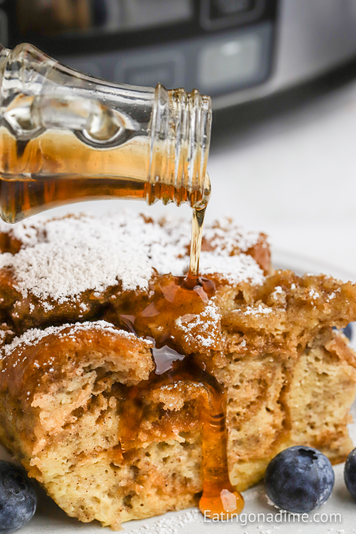 French Toast Casserole on a plate with powdered sugar and syrup