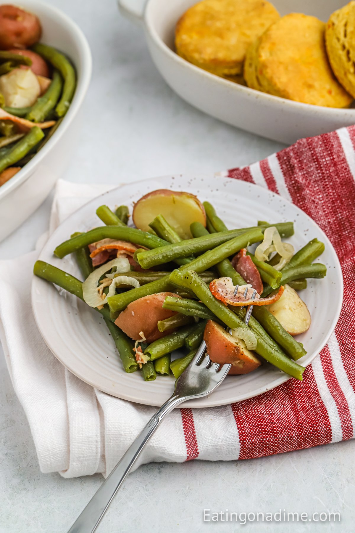 Green and potatoes on a white plate with a serving on a fork