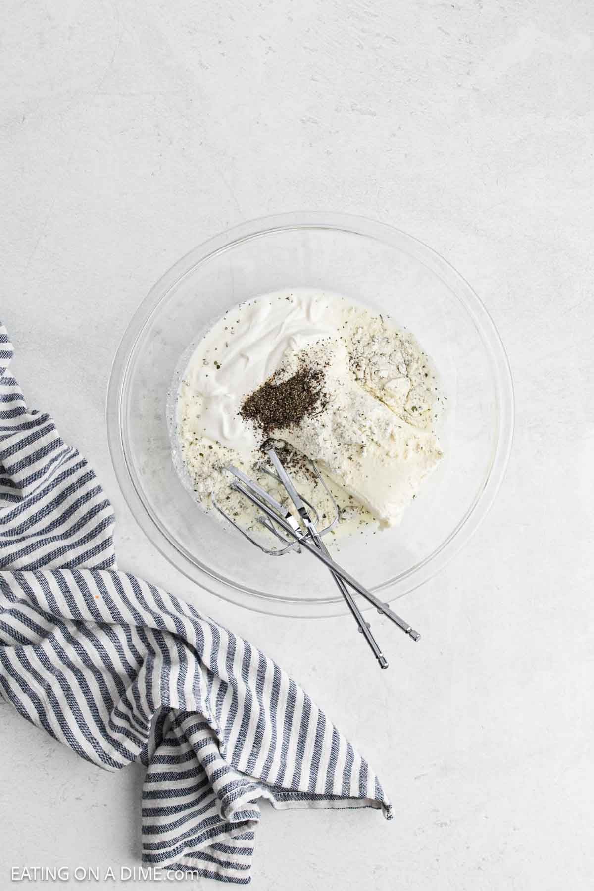 Cream cheese, sour cream, milk and spices in a bowl ready to blend.