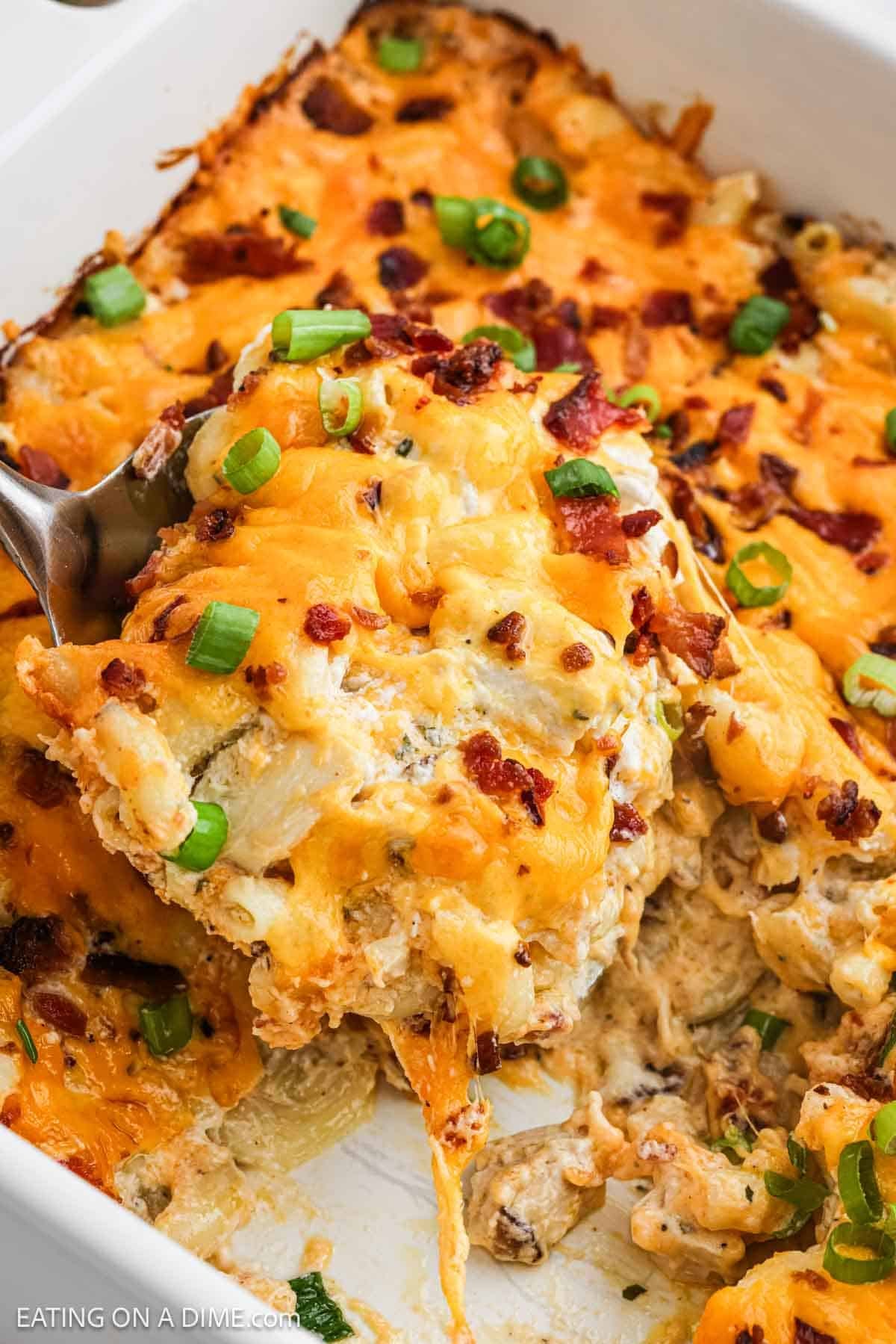 Chicken casserole in a baking dish with a serving on a spatula.