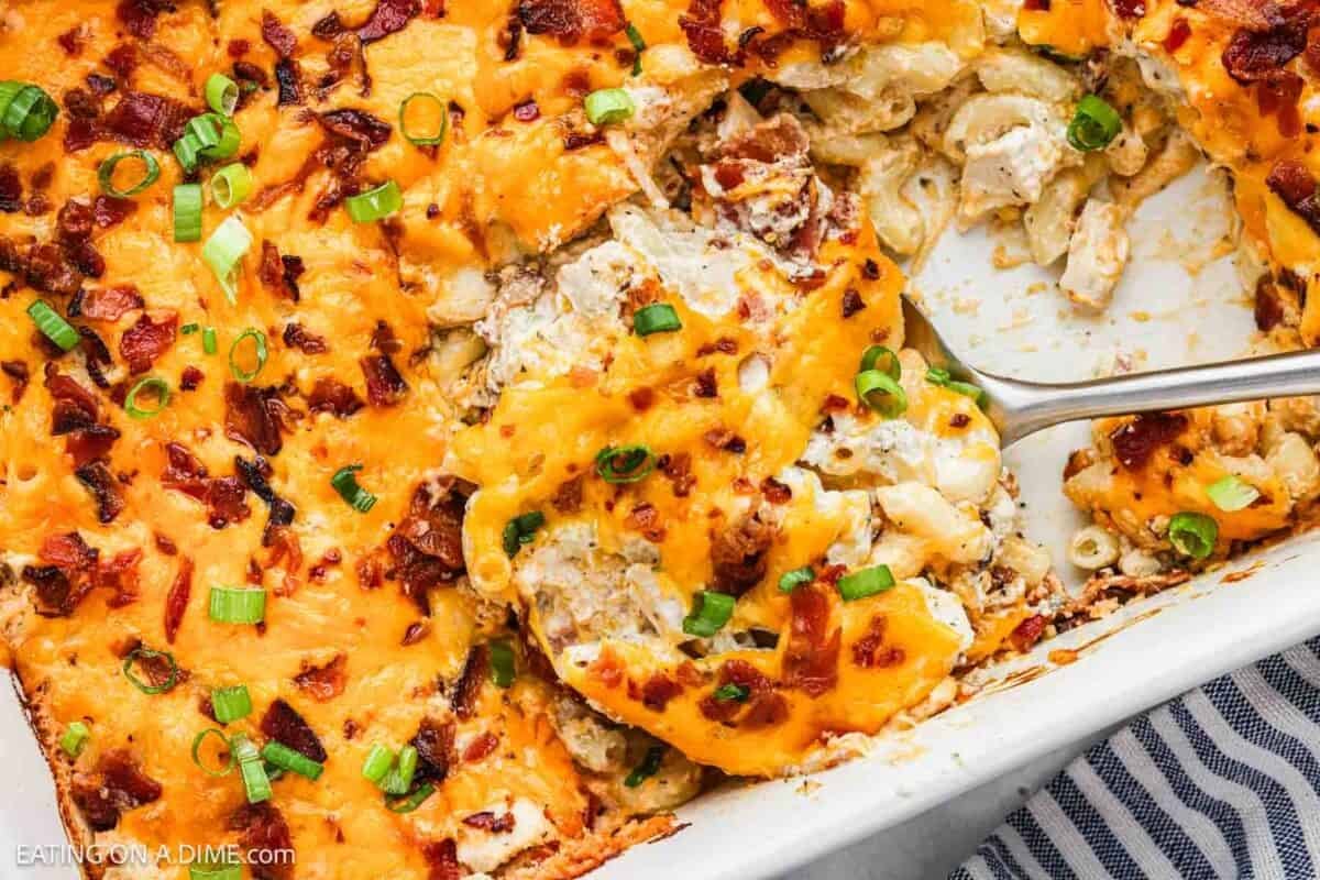 Crack chicken casserole in a baking dish topped with melted cheese, chopped bacon and green onions.