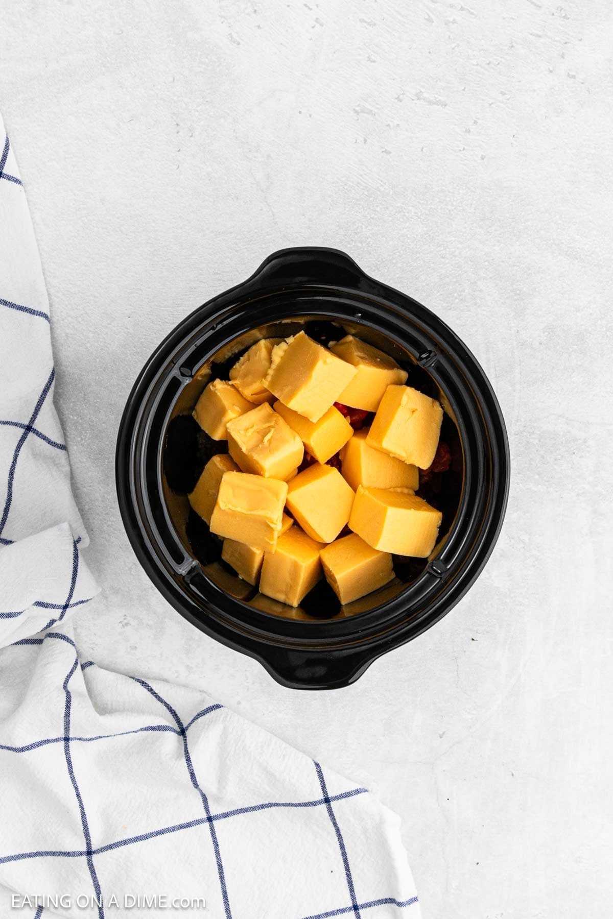 Velveeta cheese cubed and placed in the crockpot.