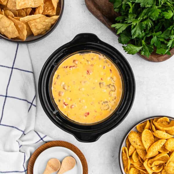 Sausage Cheese Dip in a mini crock pot with a small bowls of chips on the side.