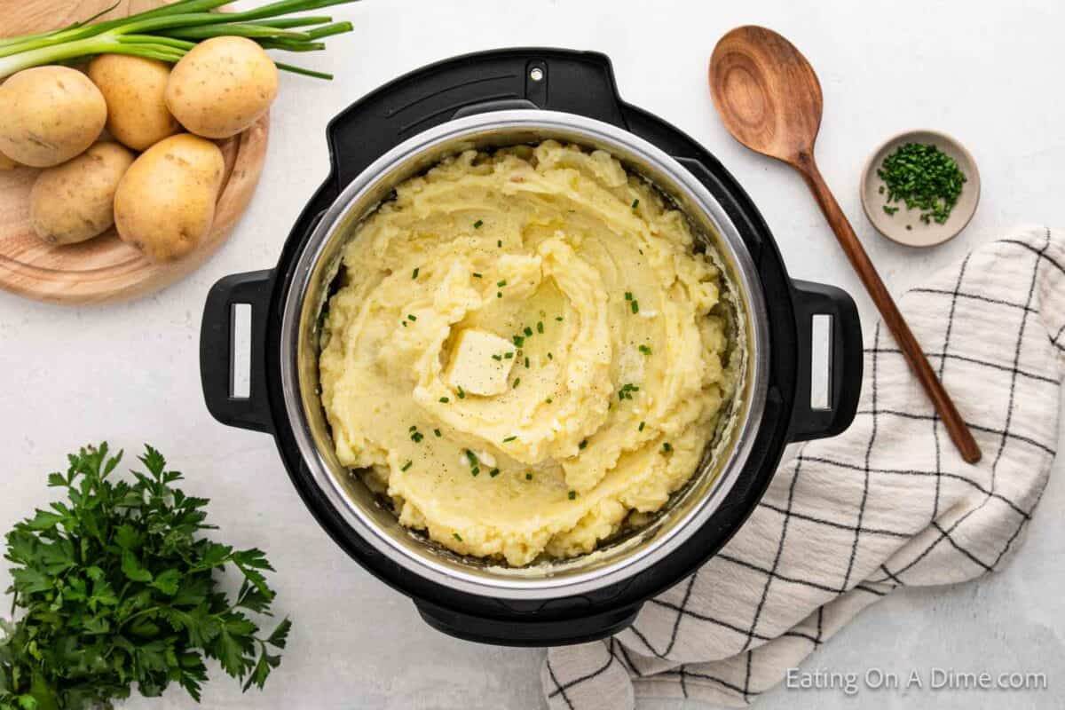 Instant Pot Mashed potatoes inside the pressure cooker with a tab of butter in the middle.
