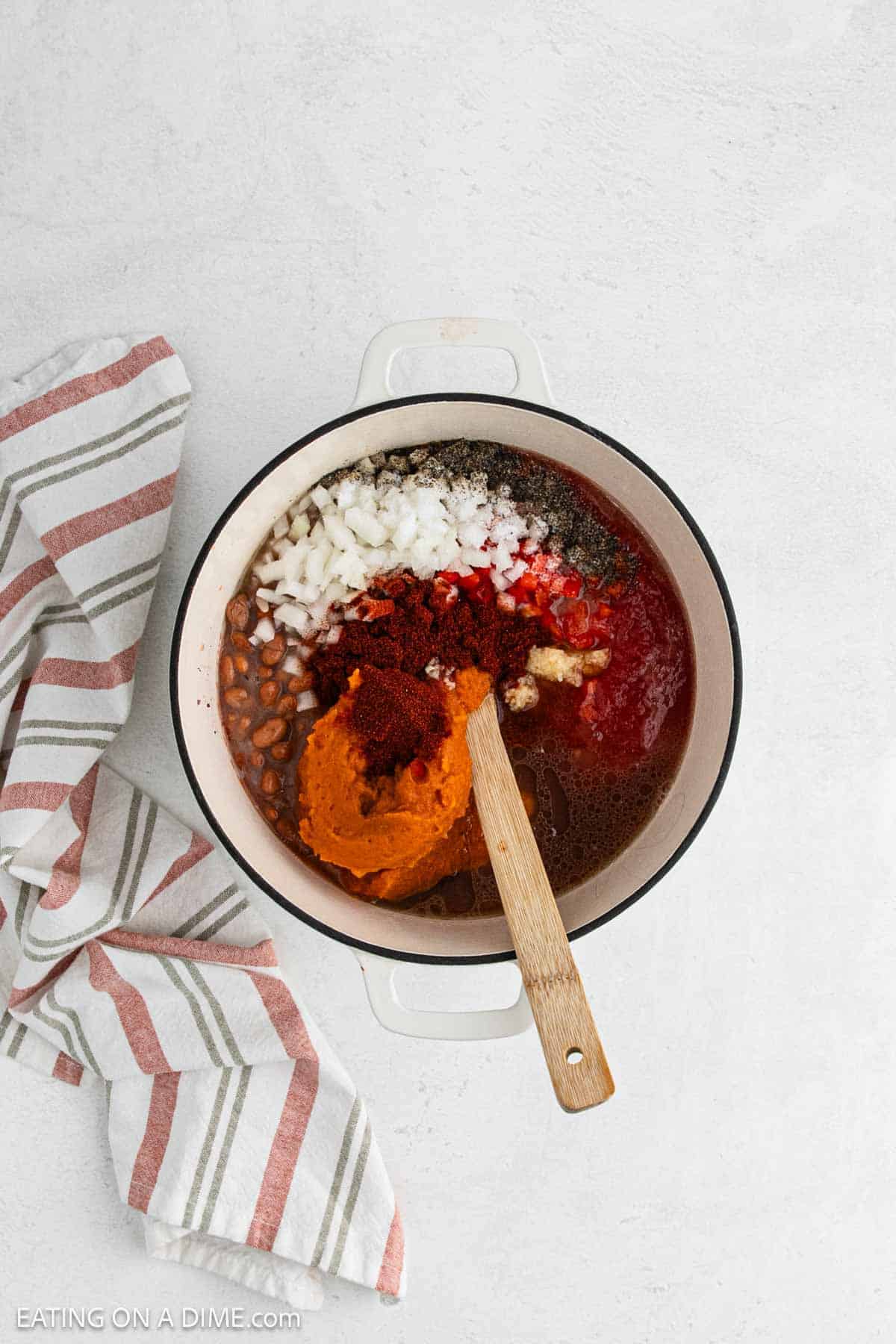 Ingredients added to the large pot with a wooden spoon.