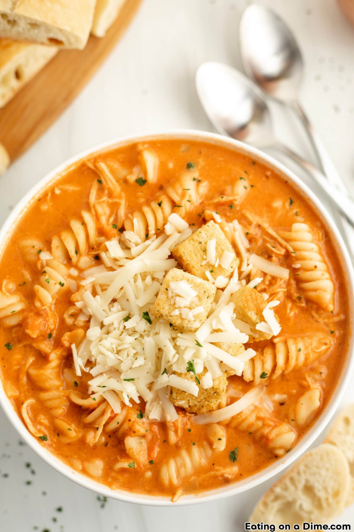 close up image of a bowl of chicken parmesan soup topped with mozzarella cheese and croutons