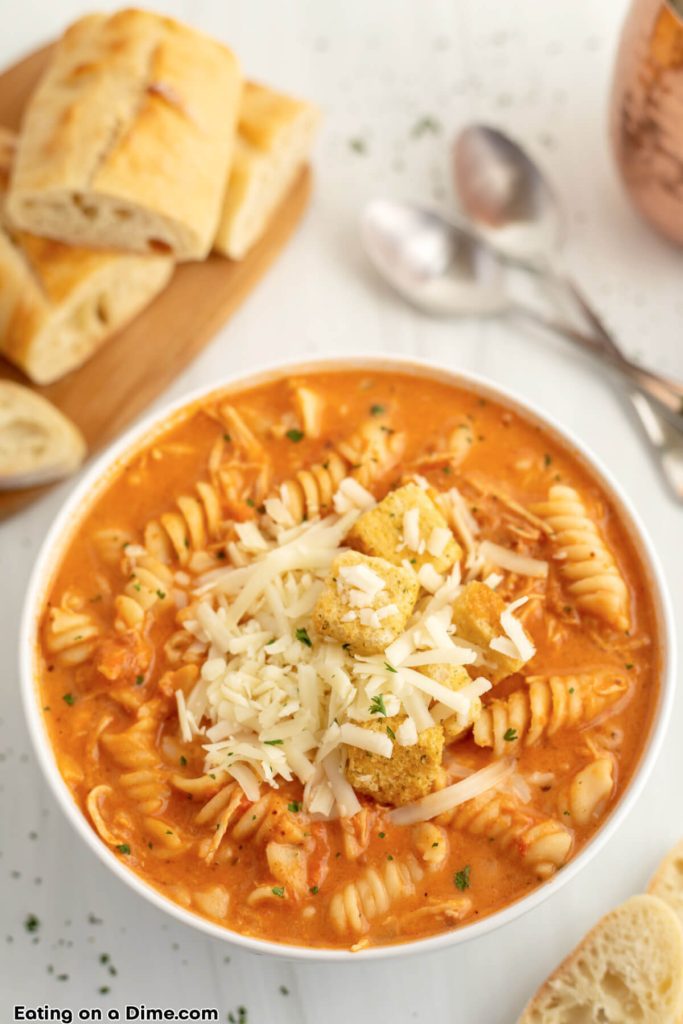 close up image of a bowl of chicken parmesan soup topped with mozzarella cheese and croutons