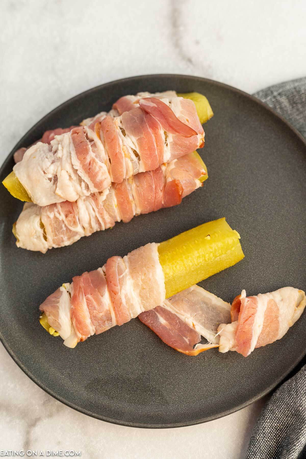 Pickle spears being wrapped in bacon. 
