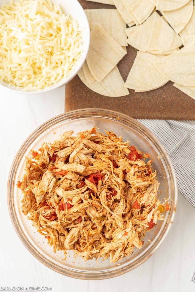Shredded cooked chicken in a bowl mixed with salsa