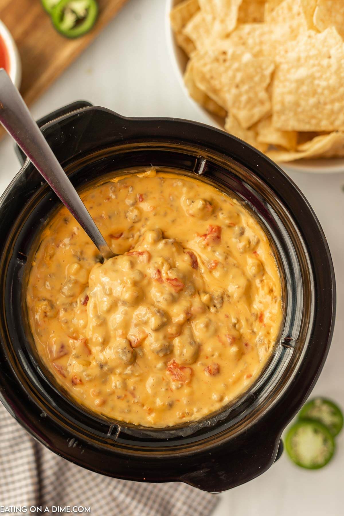 Sausage Cheese Dip in the Slow Cooker being stirred by a spoon