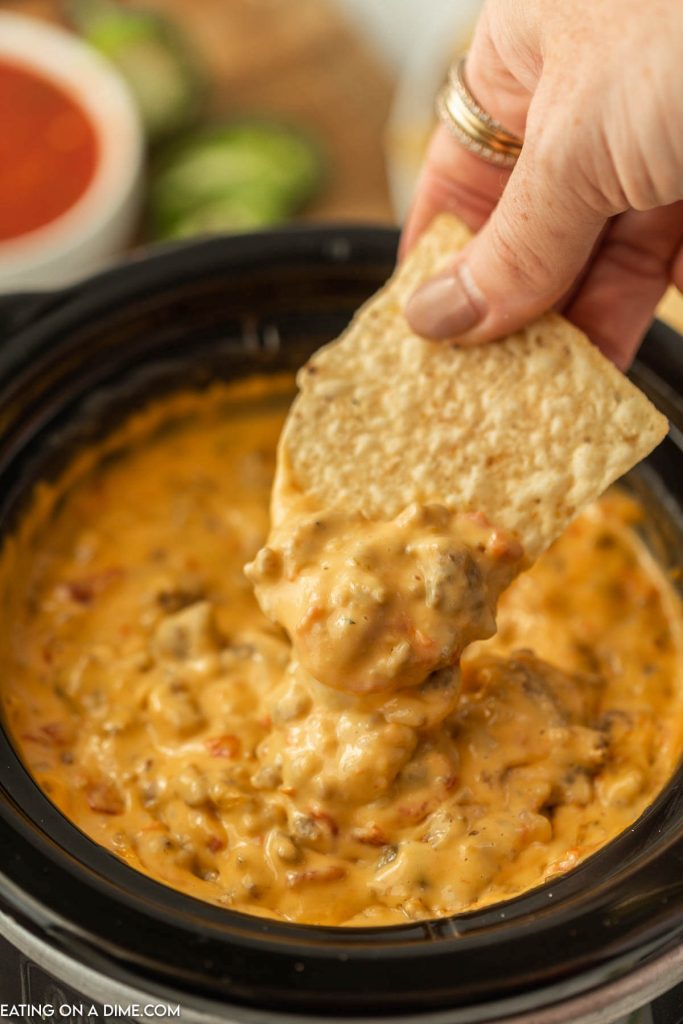 Sausage Cheese Dip in the Slow Cooker with a bite on a tortilla chips