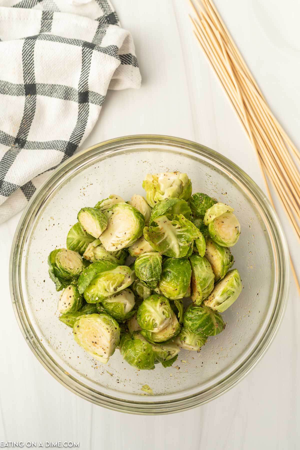 Brussel sprouts in a bowl with seasoning. 