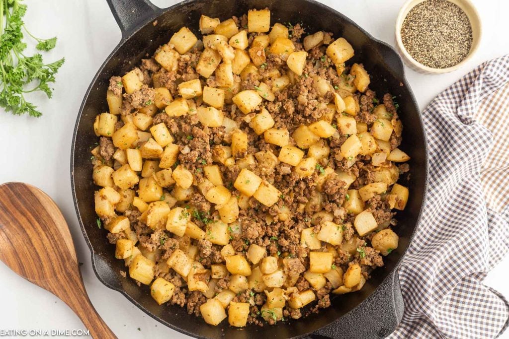 Hamburger hash in a skillet with a wooden spoon