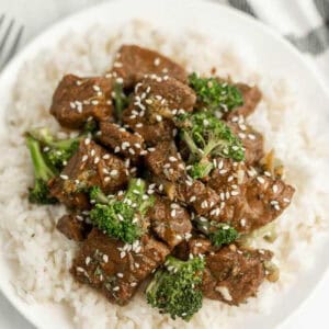 Beef and broccoli over rice on a plate.