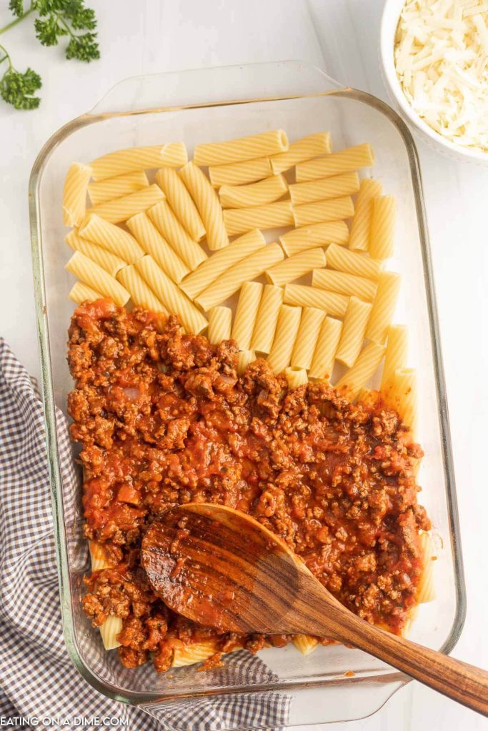 Pasta on the bottom of the baking dish and topping with meat sauce