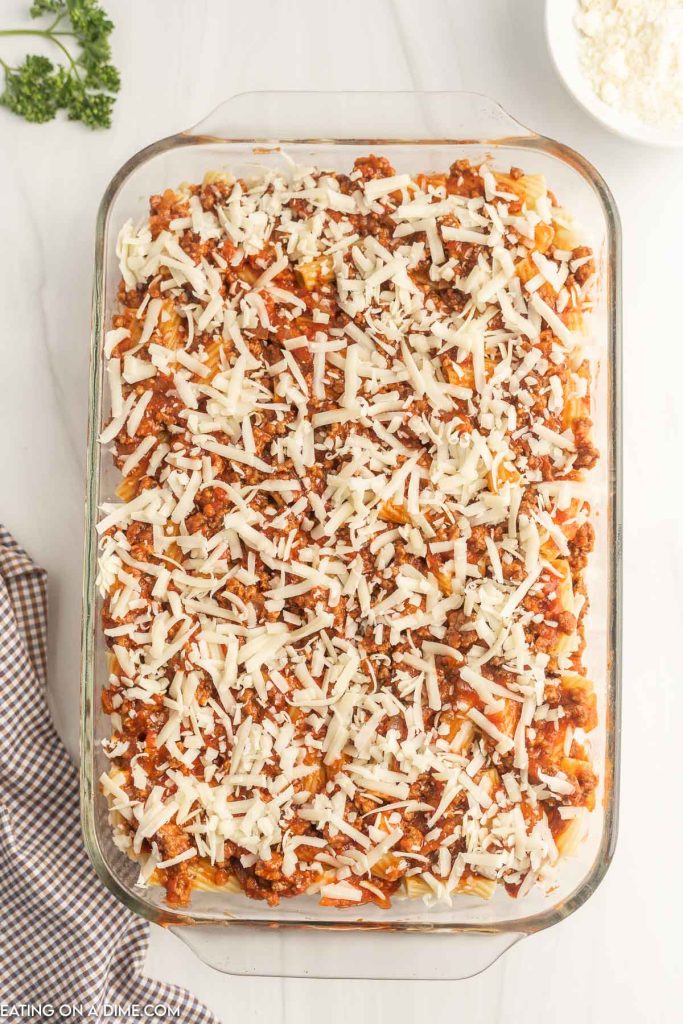 Topping the casserole with mozzarella cheese