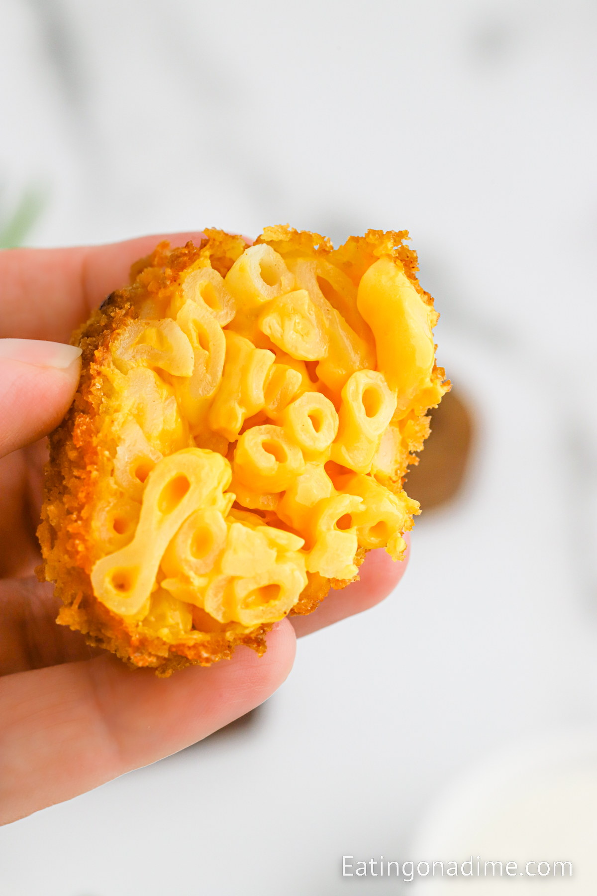 Close image of holding a half mac and cheese balls
