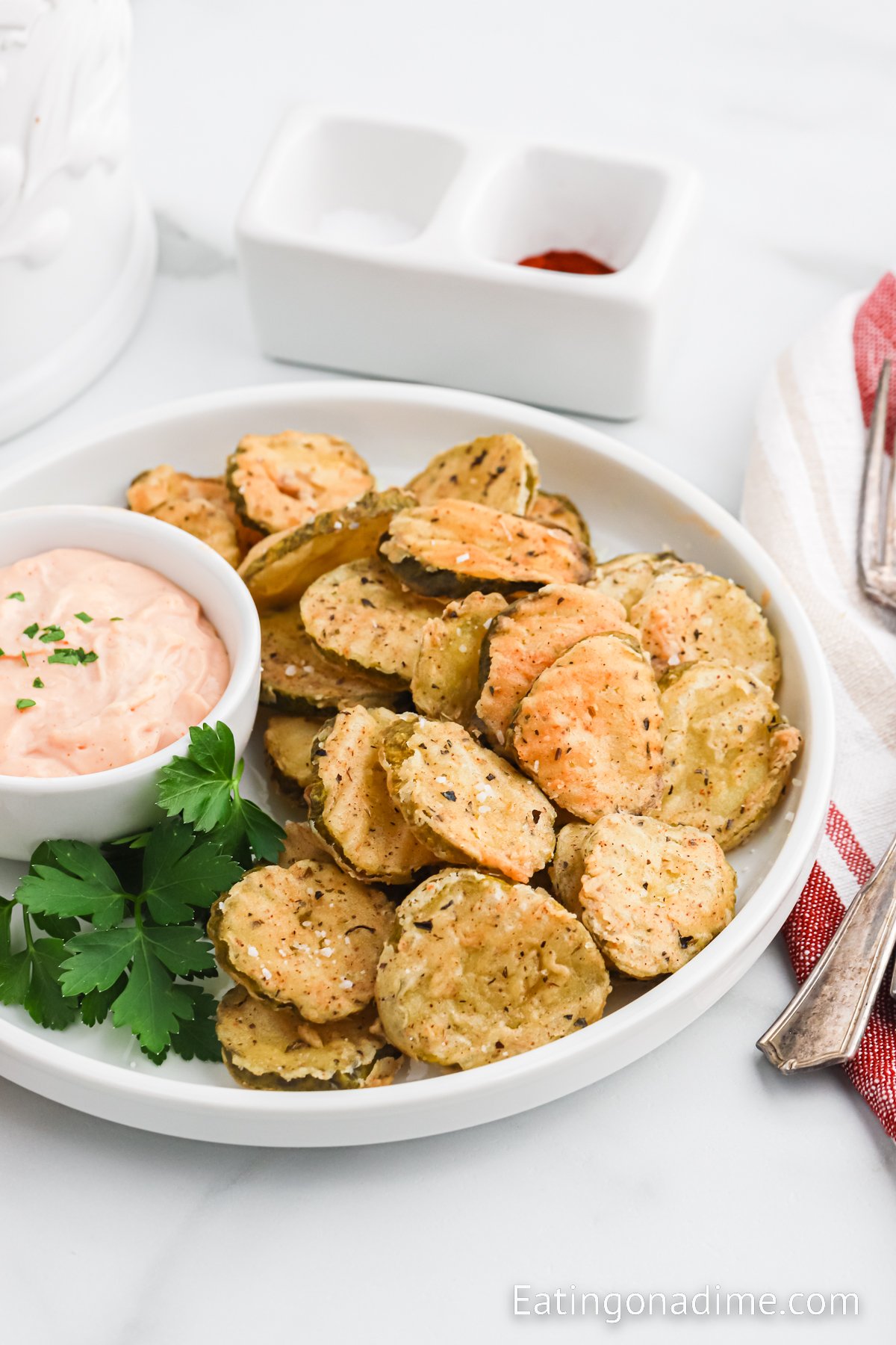 Close up image of fried pickles on a platter with dipping sauce