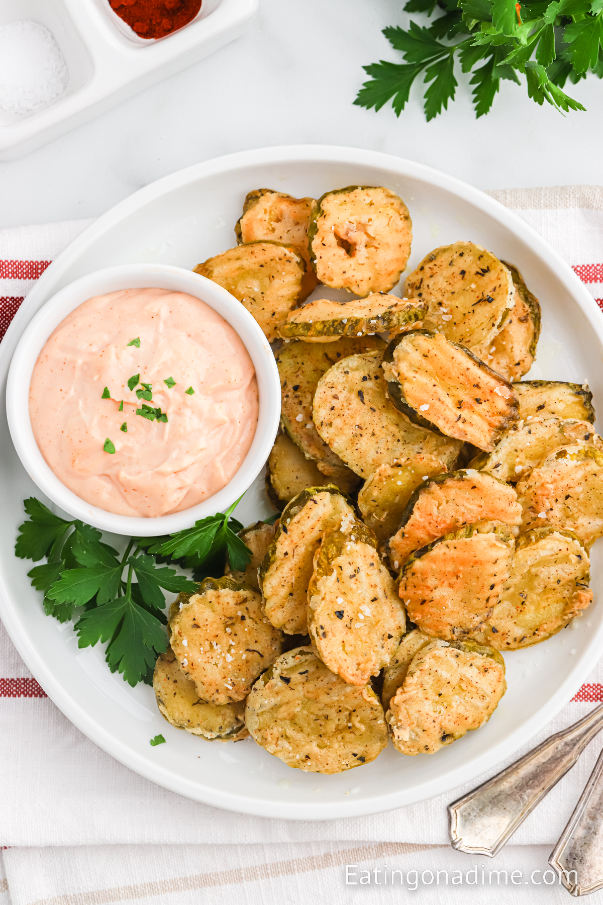 Close up image of fried pickles on a platter with dipping sauce