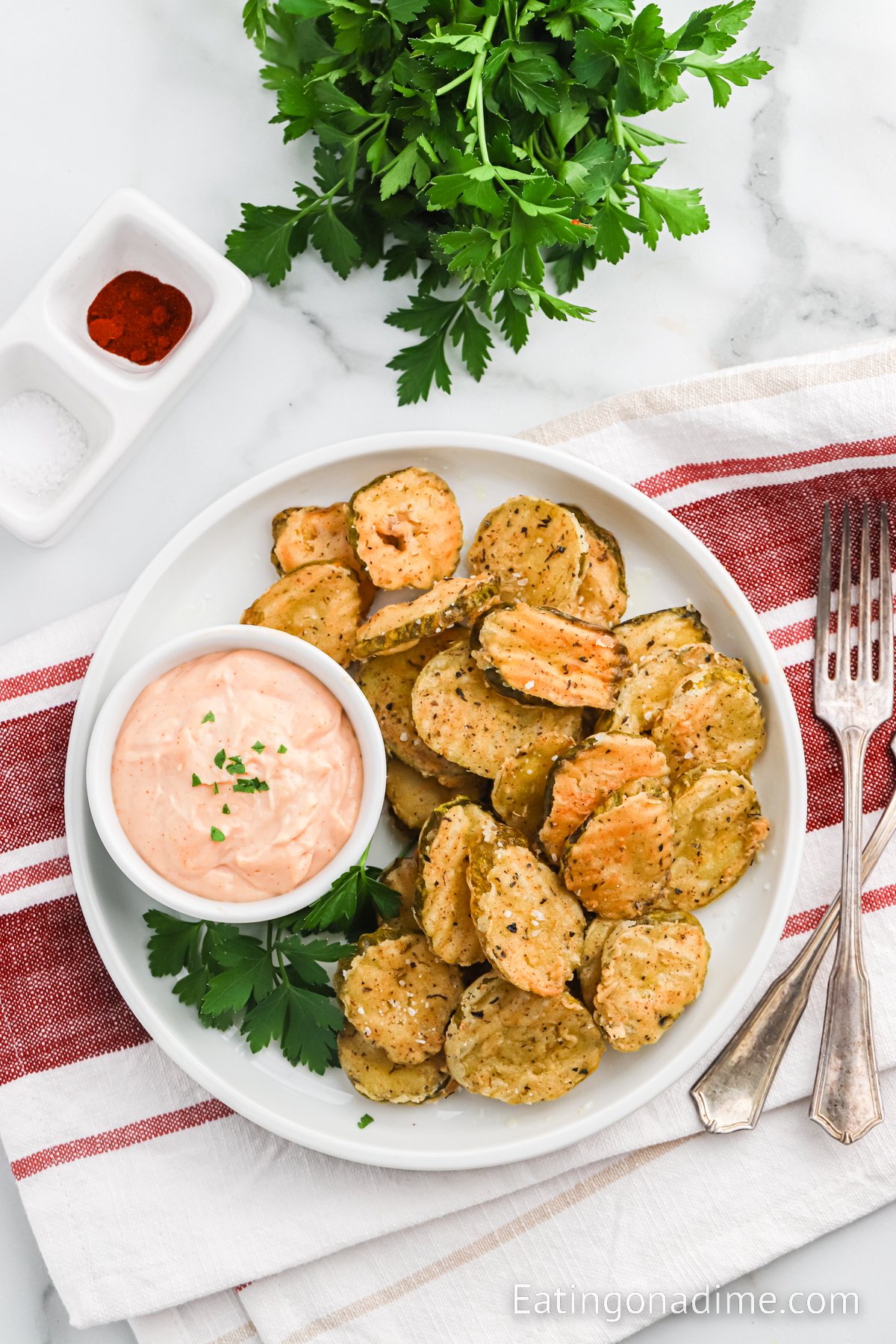 Close up image of fried pickles on a platter with dipping sauce