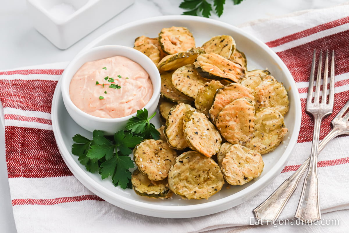 Close up image of fried pickles on a platter with dipping sauce