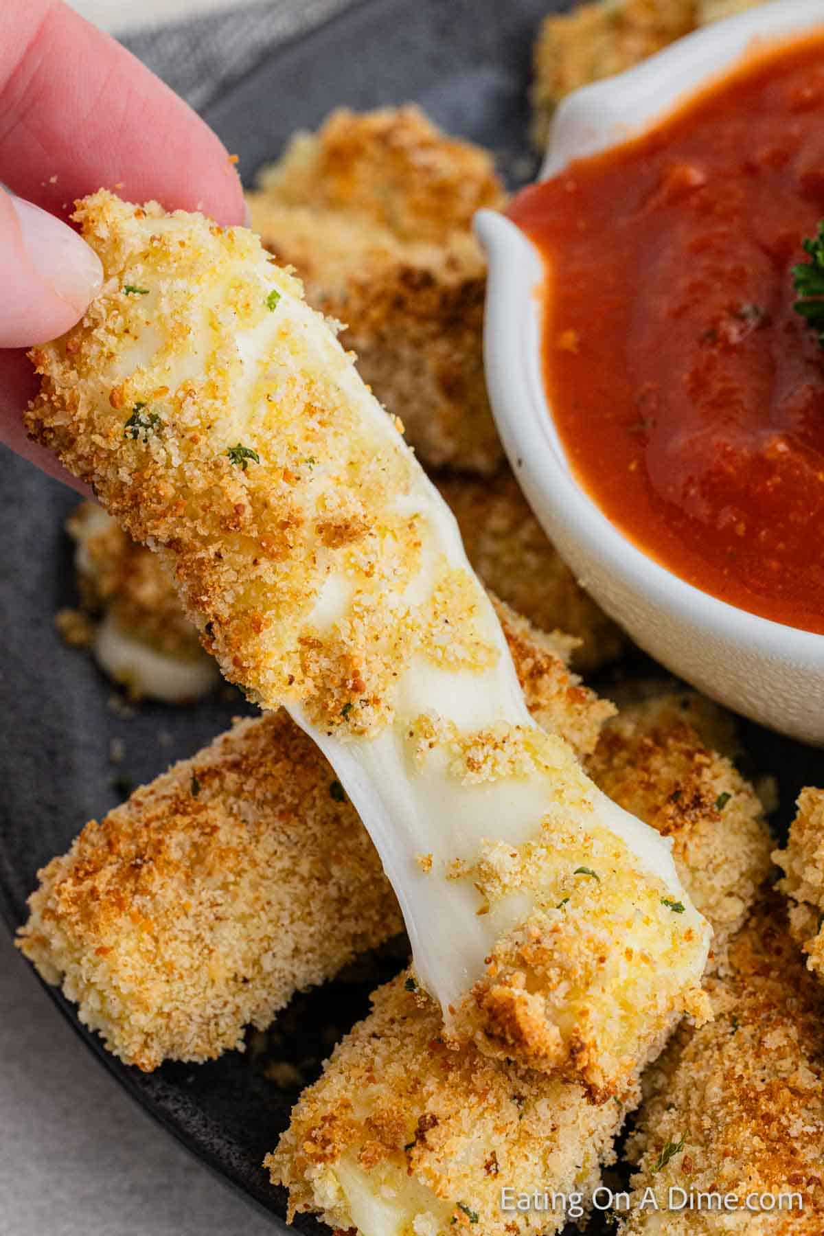 Cheese sticks on a platter with pizza sauce