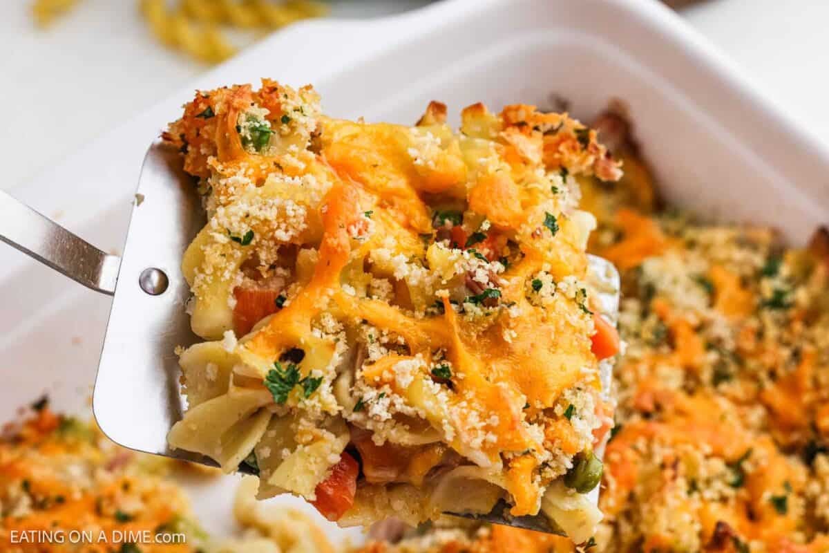 Tuna casserole in a baking dish with a serving raising out of the baking dish with a spatula.