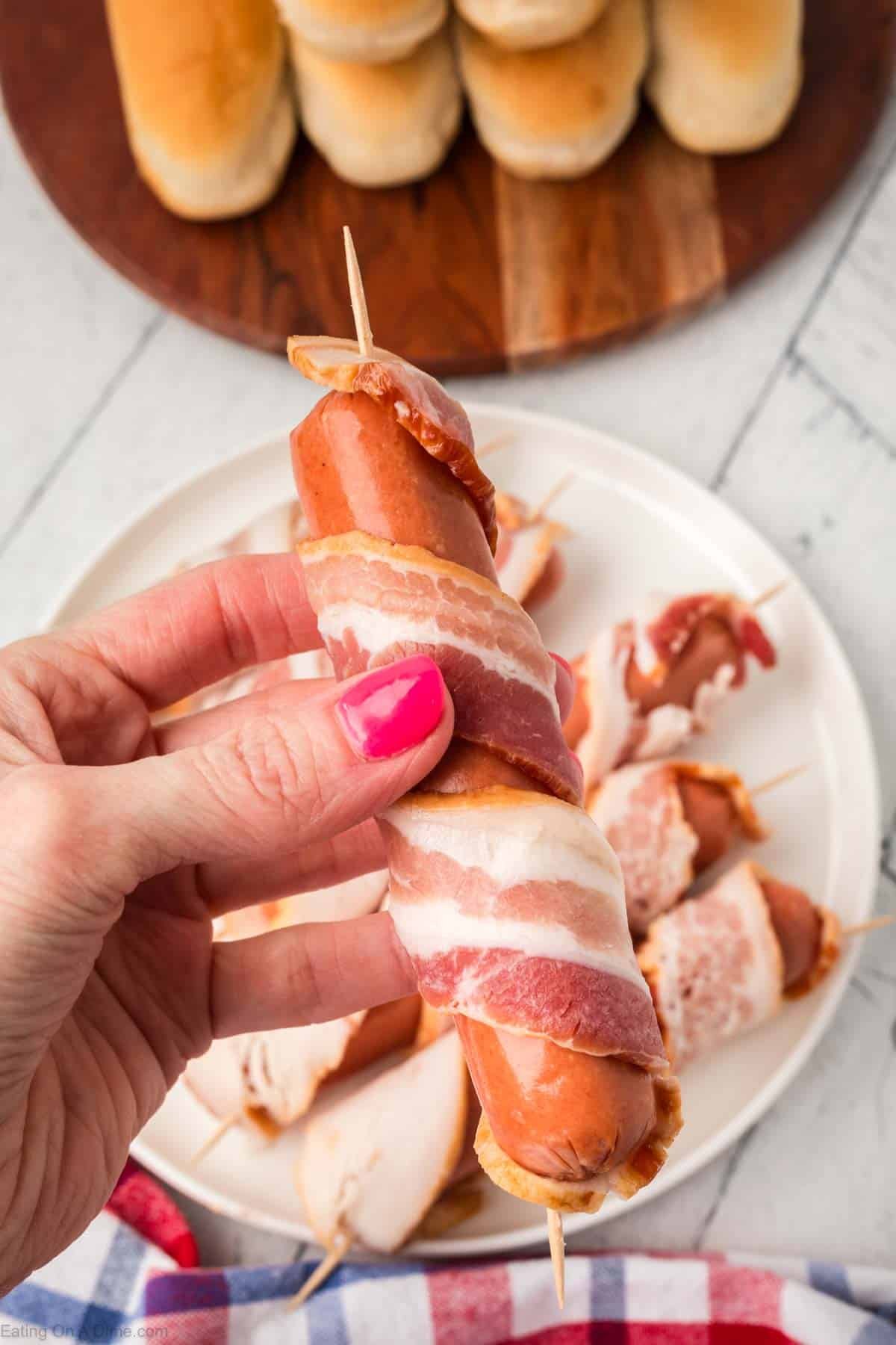 Wrapping bacon around hot dog and securing with a toothpick