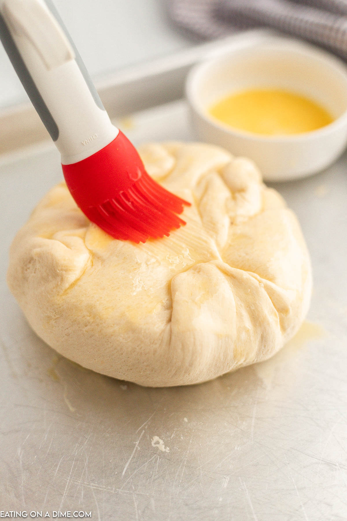 Brush egg wash on the uncooked baked brie