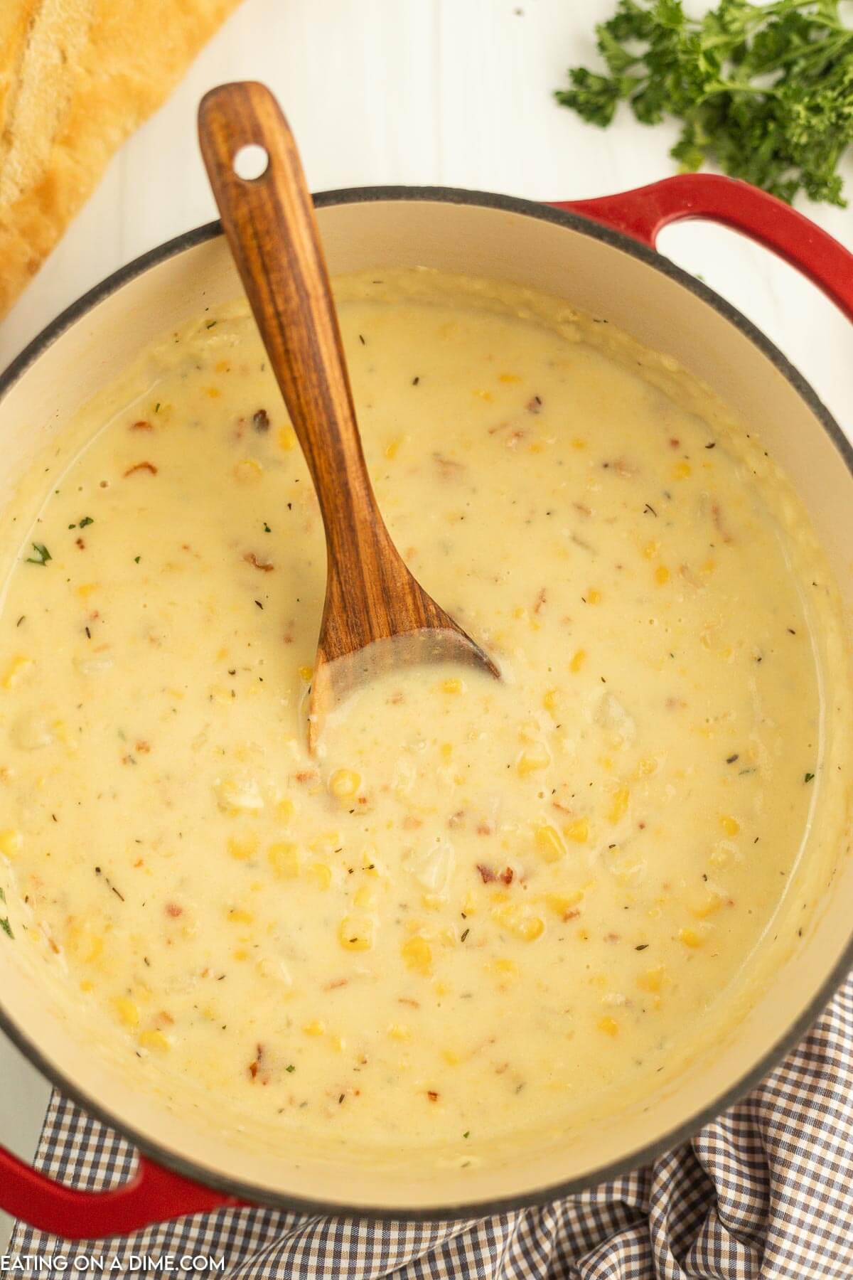 Corn Chowder in a dutch oven with a wooden spoon