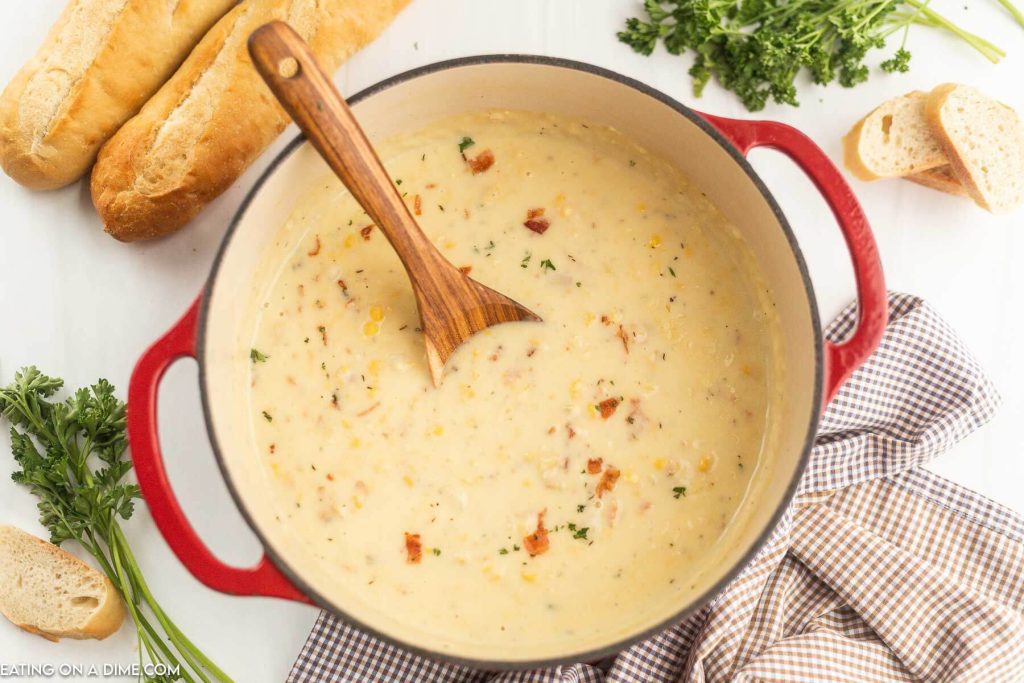 Corn Chowder in a dutch oven with a wooden spoon