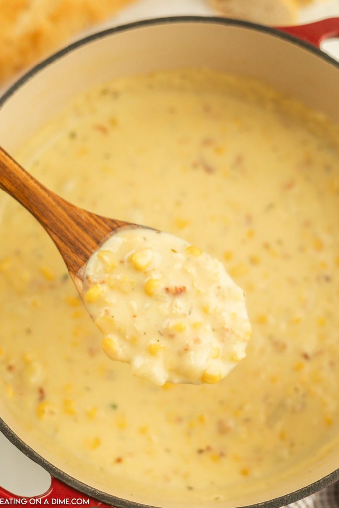 Corn Chowder in a dutch oven with a serving on a wooden spoon