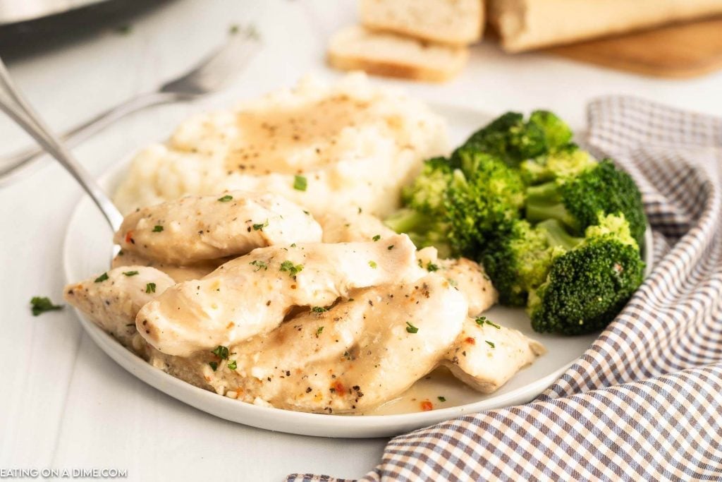 Chicken Tenders on a plate with mashed potatoes and grave with a side of broccoli
