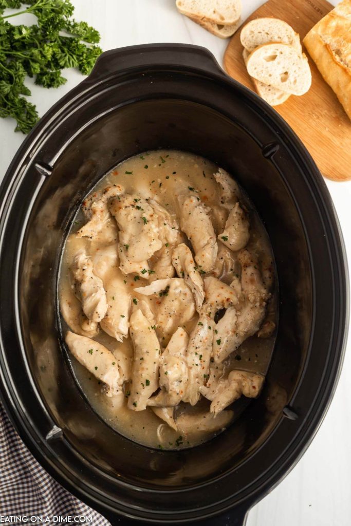 Cooked chicken tenders and gravy in the slow cooker