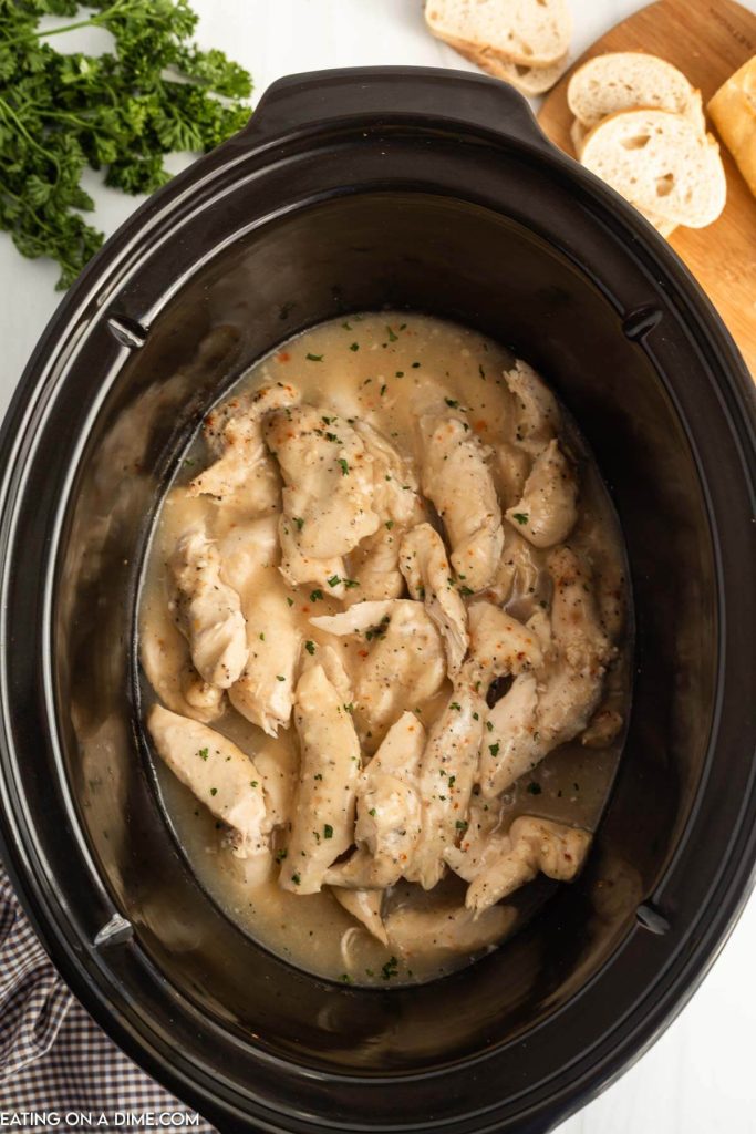 Cooked chicken tenders and gravy in a slow cooker