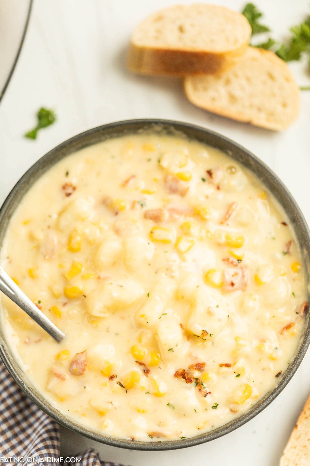 Corn Chowder in a black bowl with a spoon