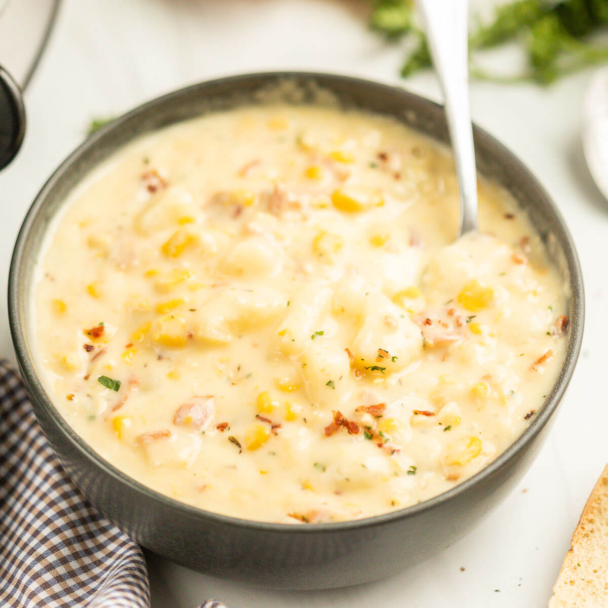Corn Chowder in a black bowl with a spoon