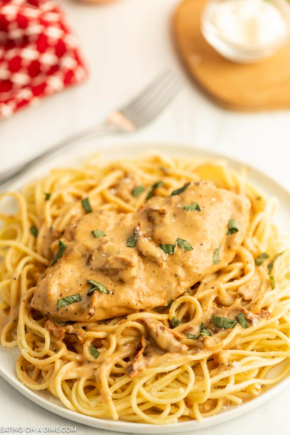 Marry Me Chicken over spaghetti noodles on a plate