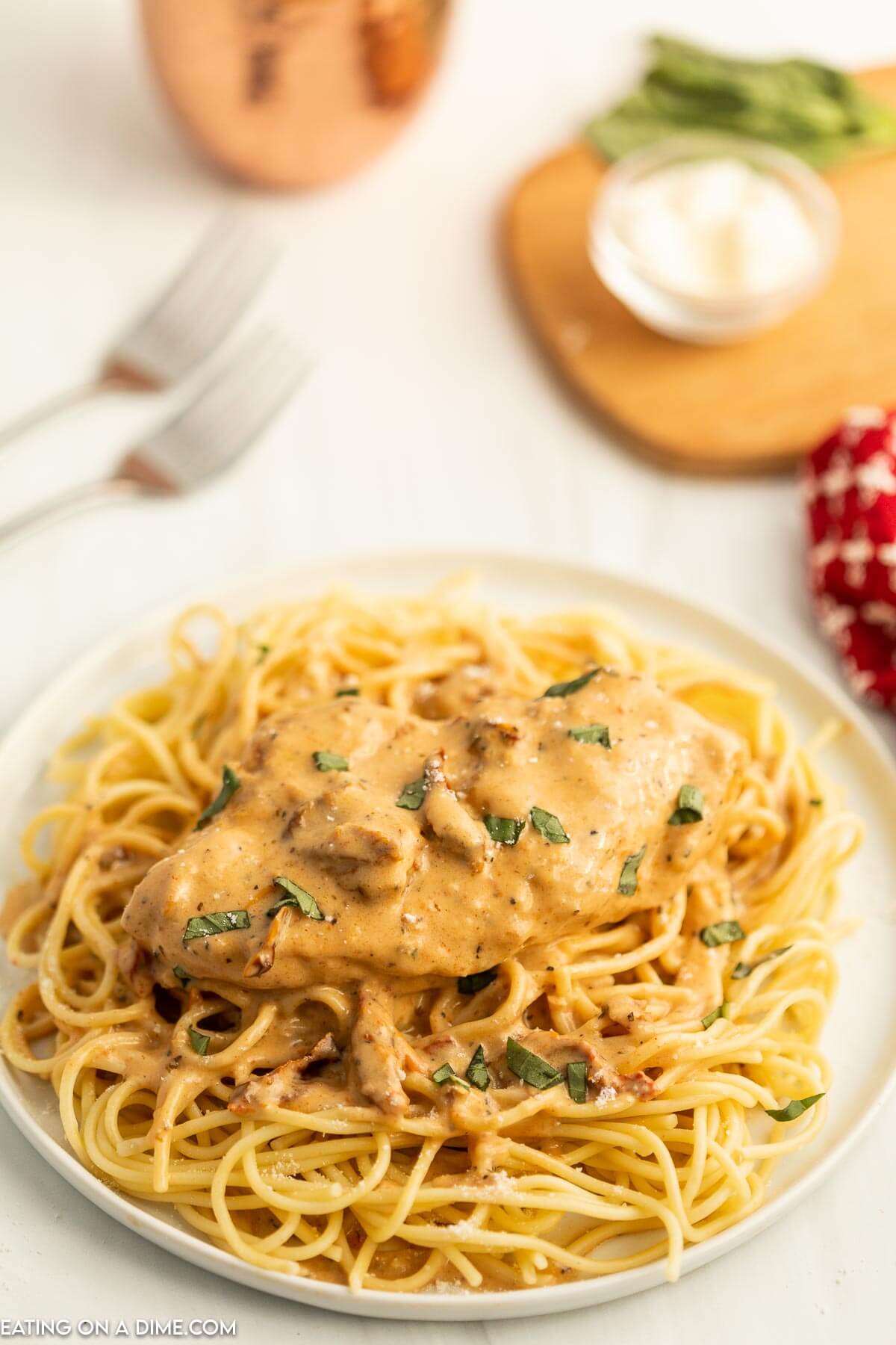 Marry Me Chicken over spaghetti noodles on a plate